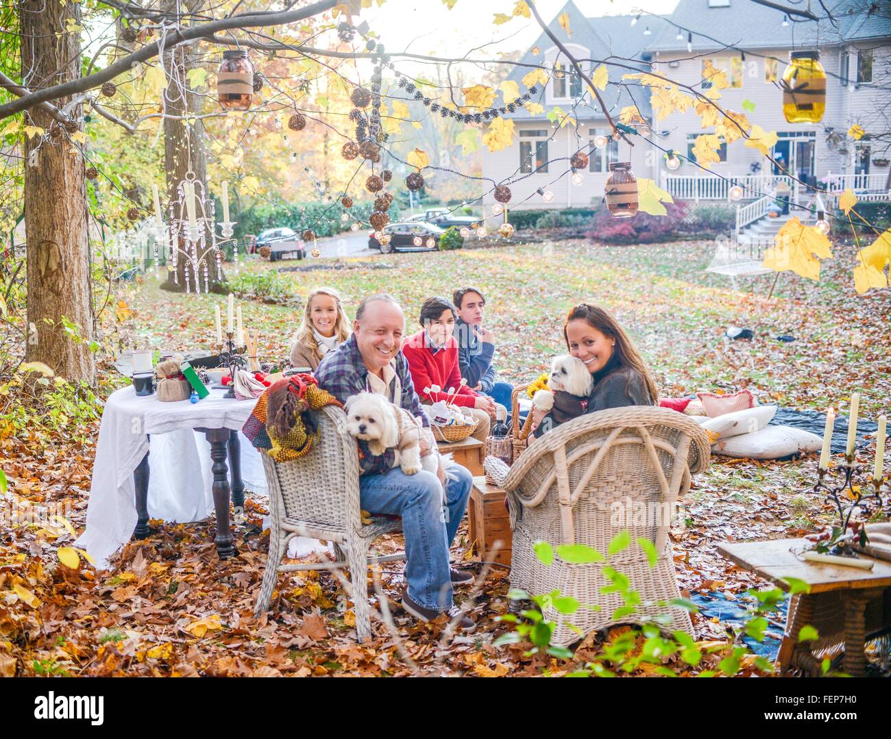 Portrait of mature couple with teenage and adult children picnicing in garden Stock Photo