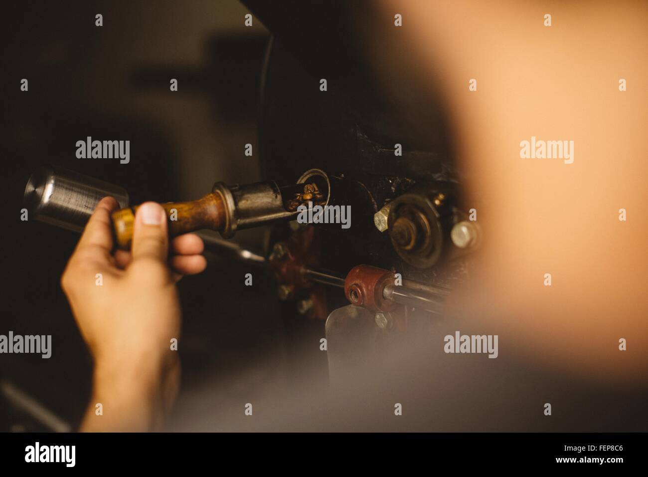 Man pouring coffee beans into coffee roaster, rear view Stock Photo
