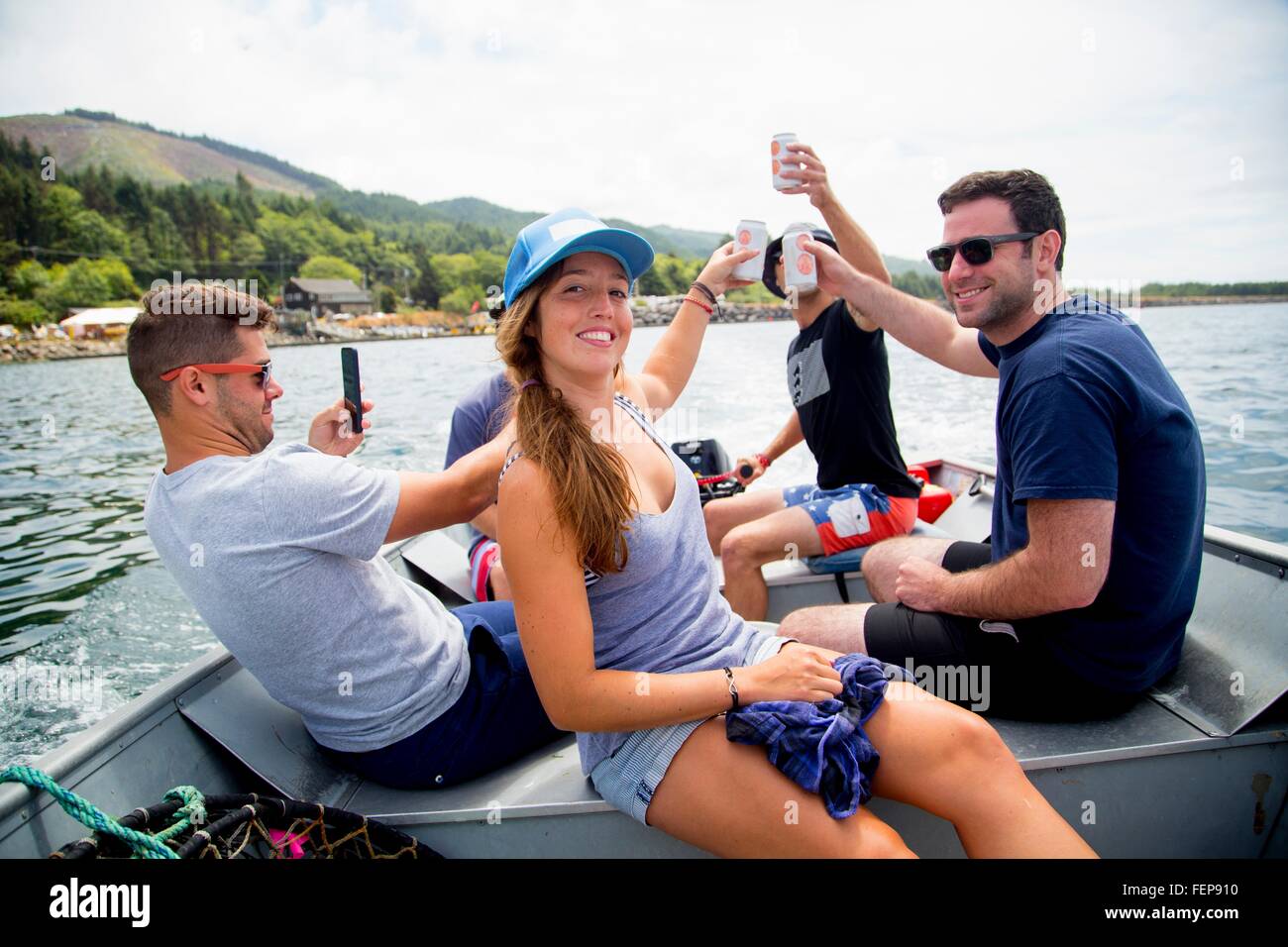 Five adult friends raising a beer can on fishing boat at Nehalem Bay, Oregon, USA Stock Photo
