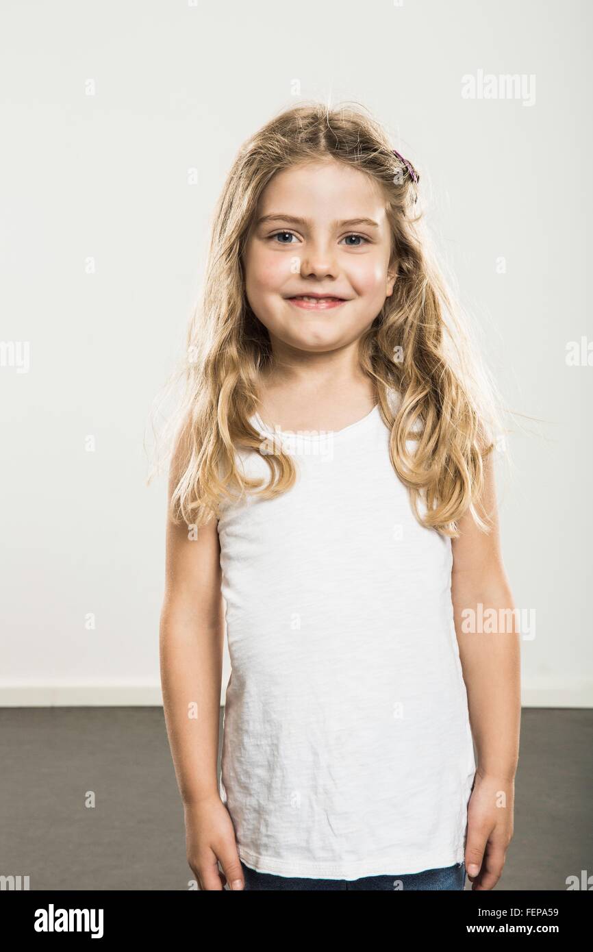 Studio portrait of cute girl with long blond hair Stock Photo