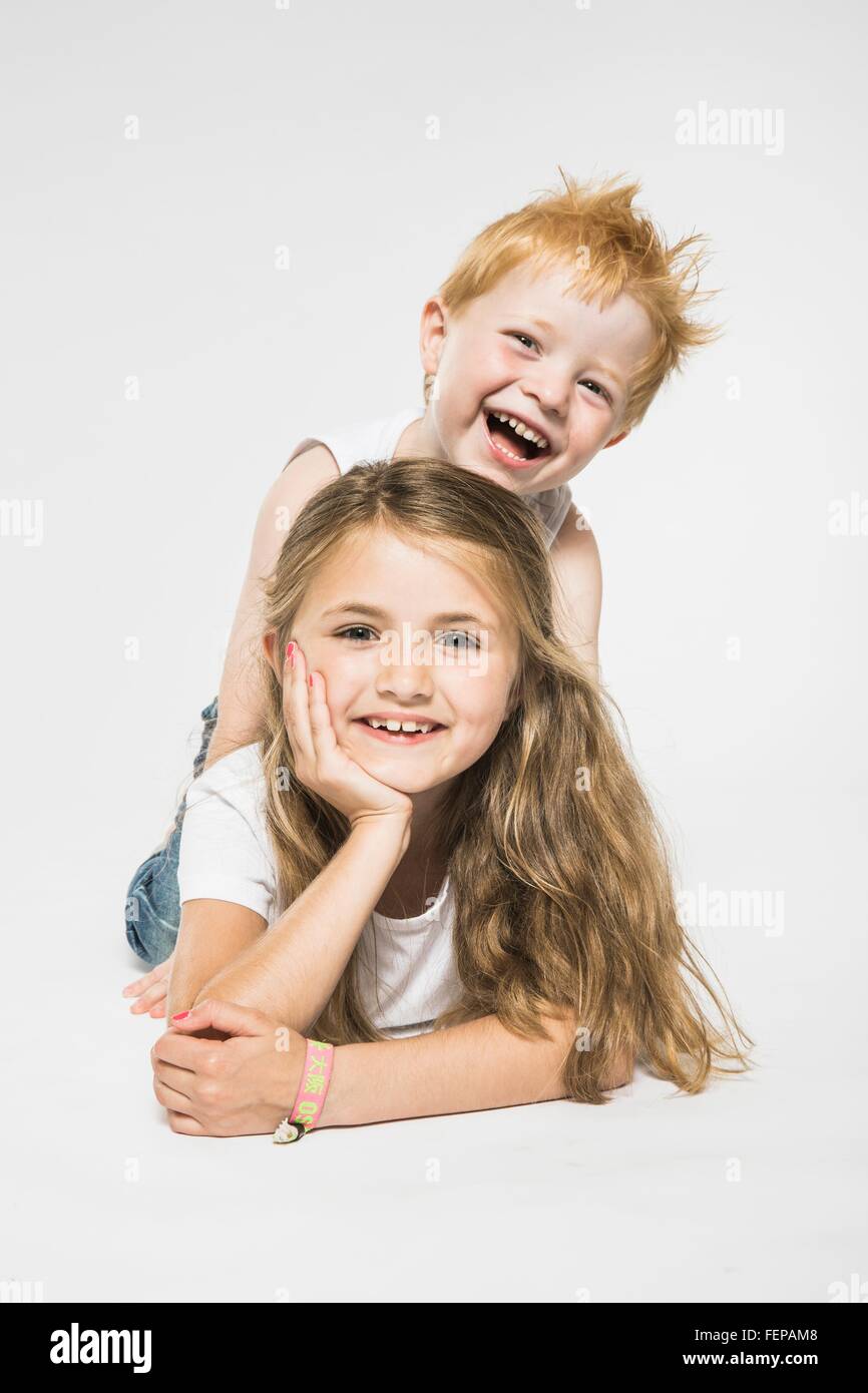 Studio portrait of boy getting piggy from sister Stock Photo