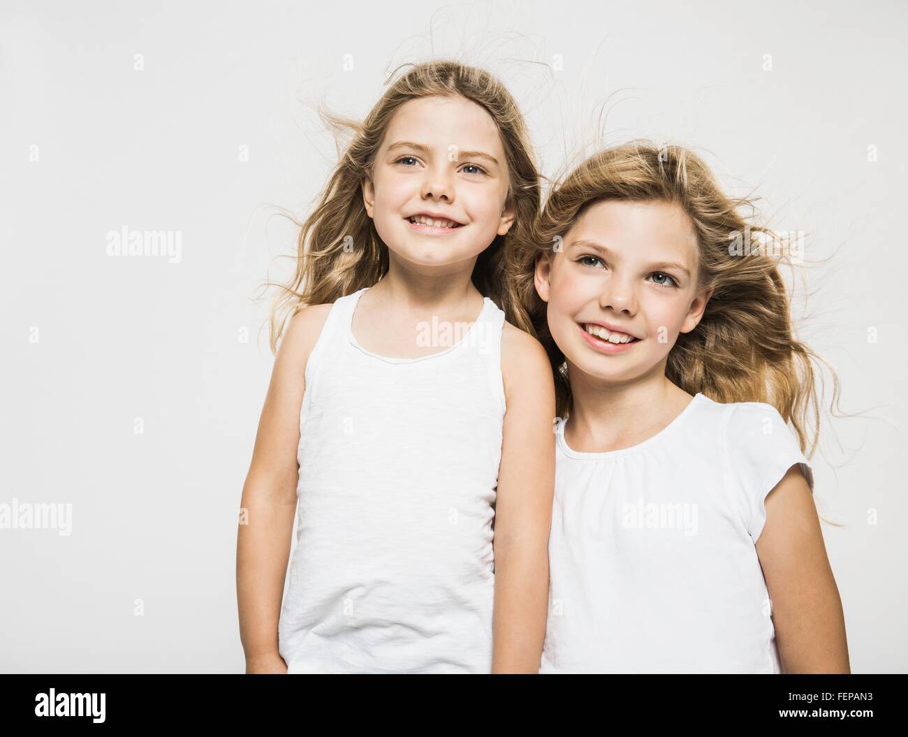 Studio portrait of two sisters with blond flyaway hair Stock Photo