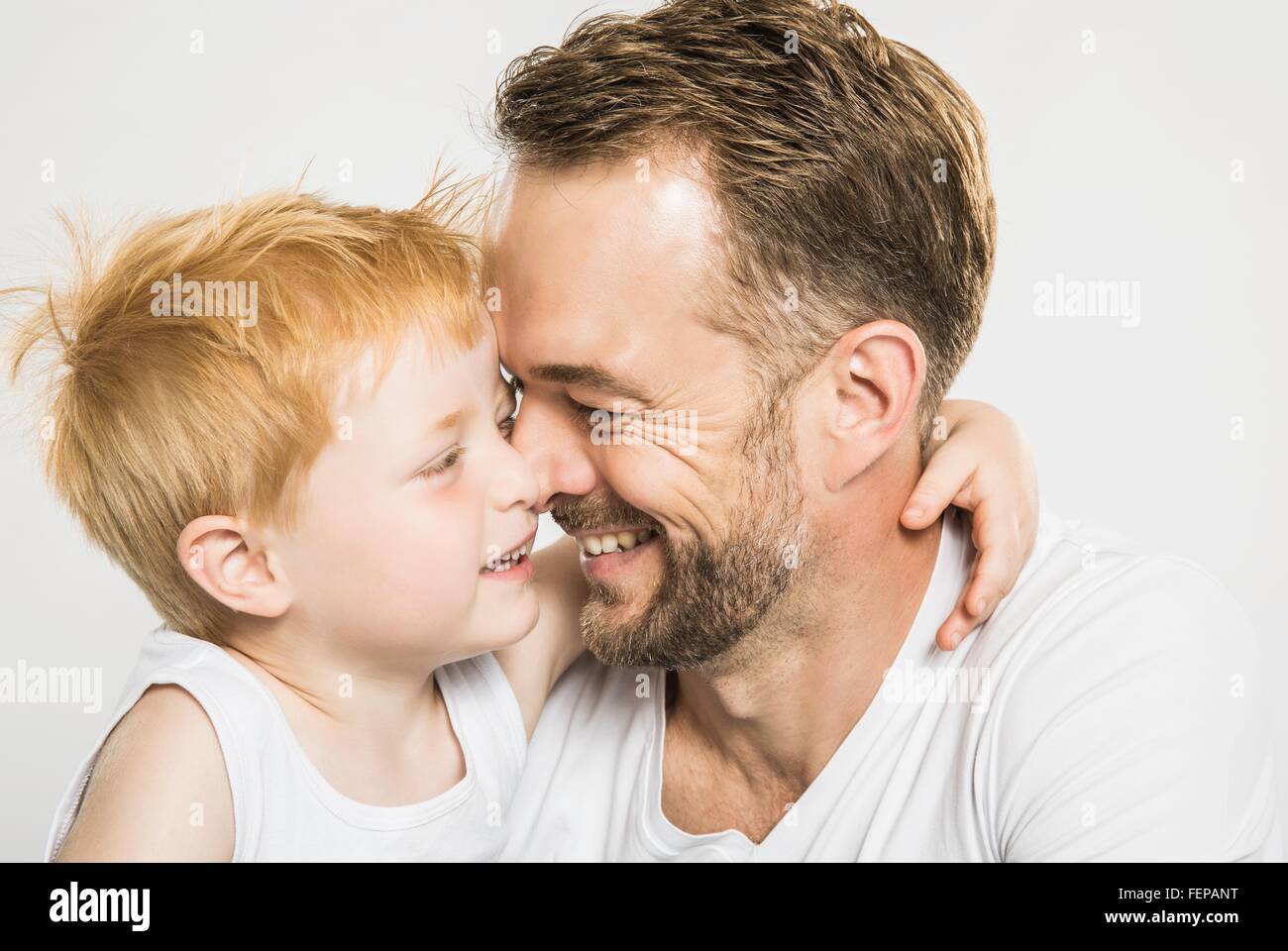 Studio portrait of mature man face to face with son Stock Photo