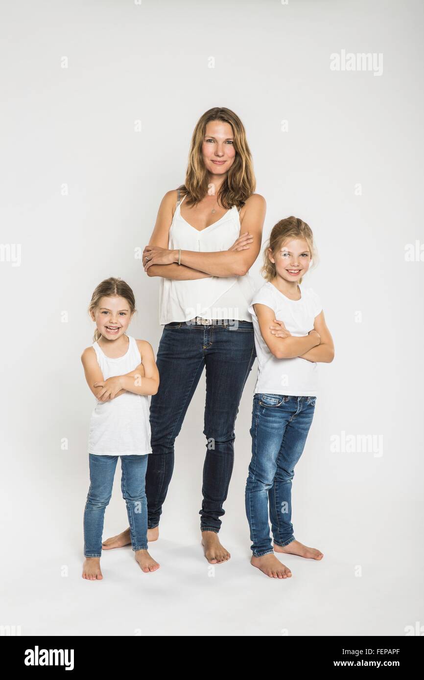 Studio portrait of two sisters and mother with arms folded Stock Photo