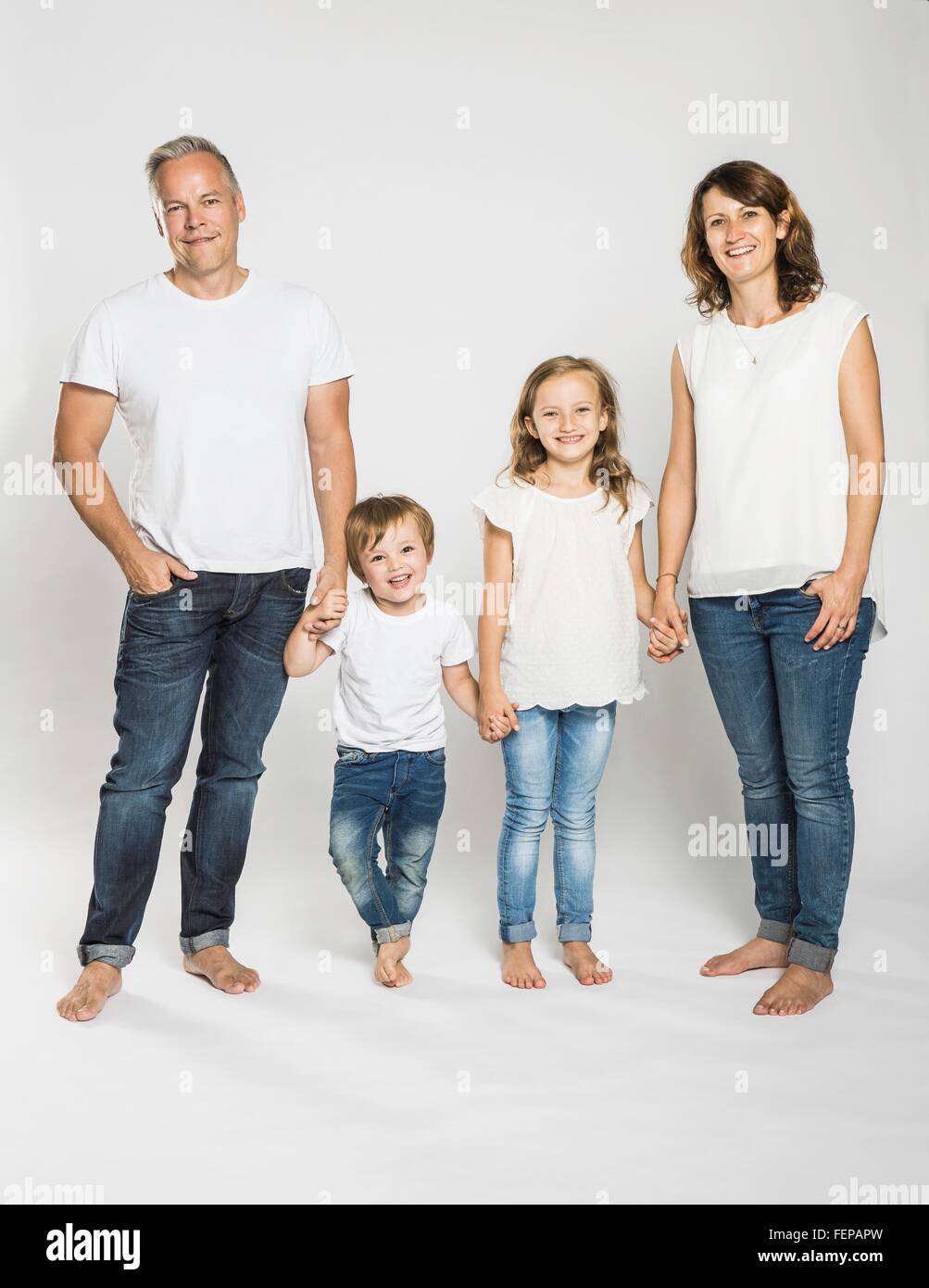 Studio portrait of parents holding hands with son and daughter Stock Photo