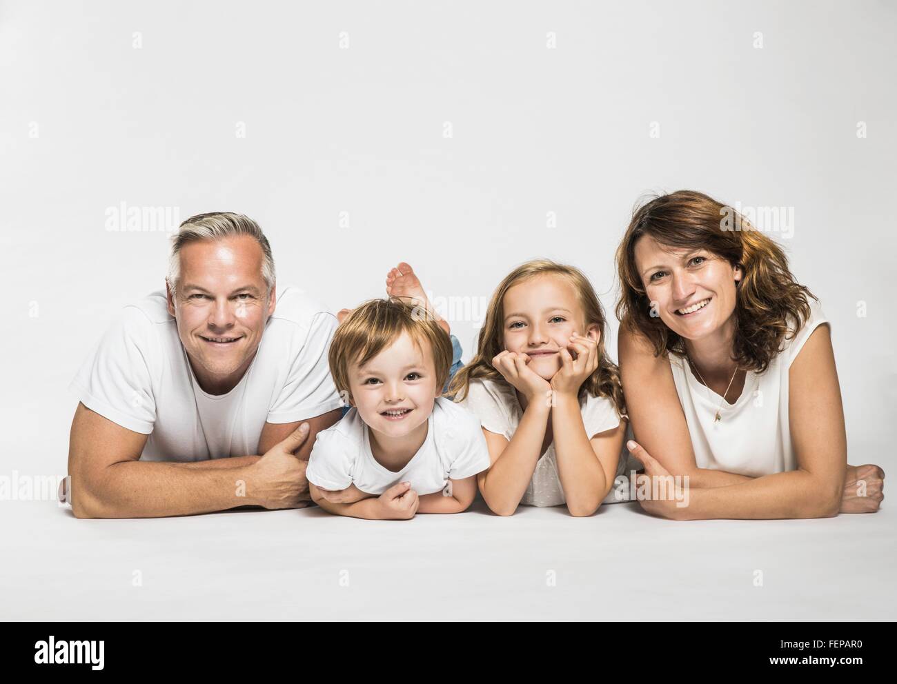 Studio portrait of parents lying on their front with son and daughter Stock Photo