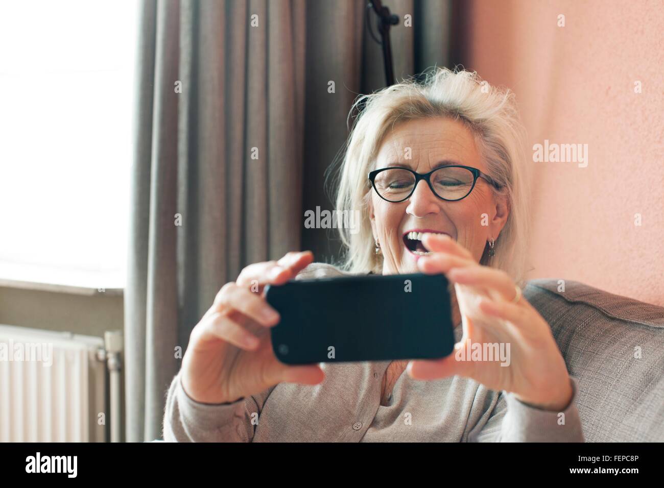 Senior woman, holding smartphone, on video call Stock Photo
