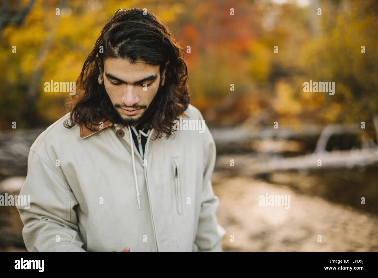 Young man, in rural environment, looking down Stock Photo