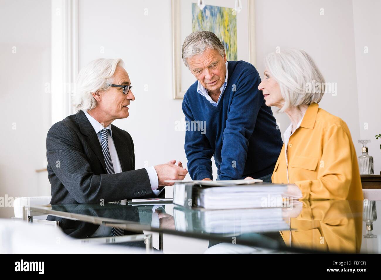 Senior adults in business meeting discussing paperwork Stock Photo
