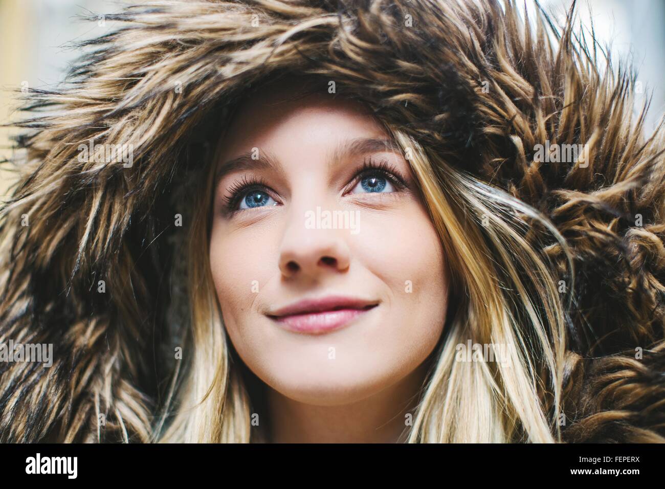 Close up portrait of young woman wearing fur hooded parka Stock Photo