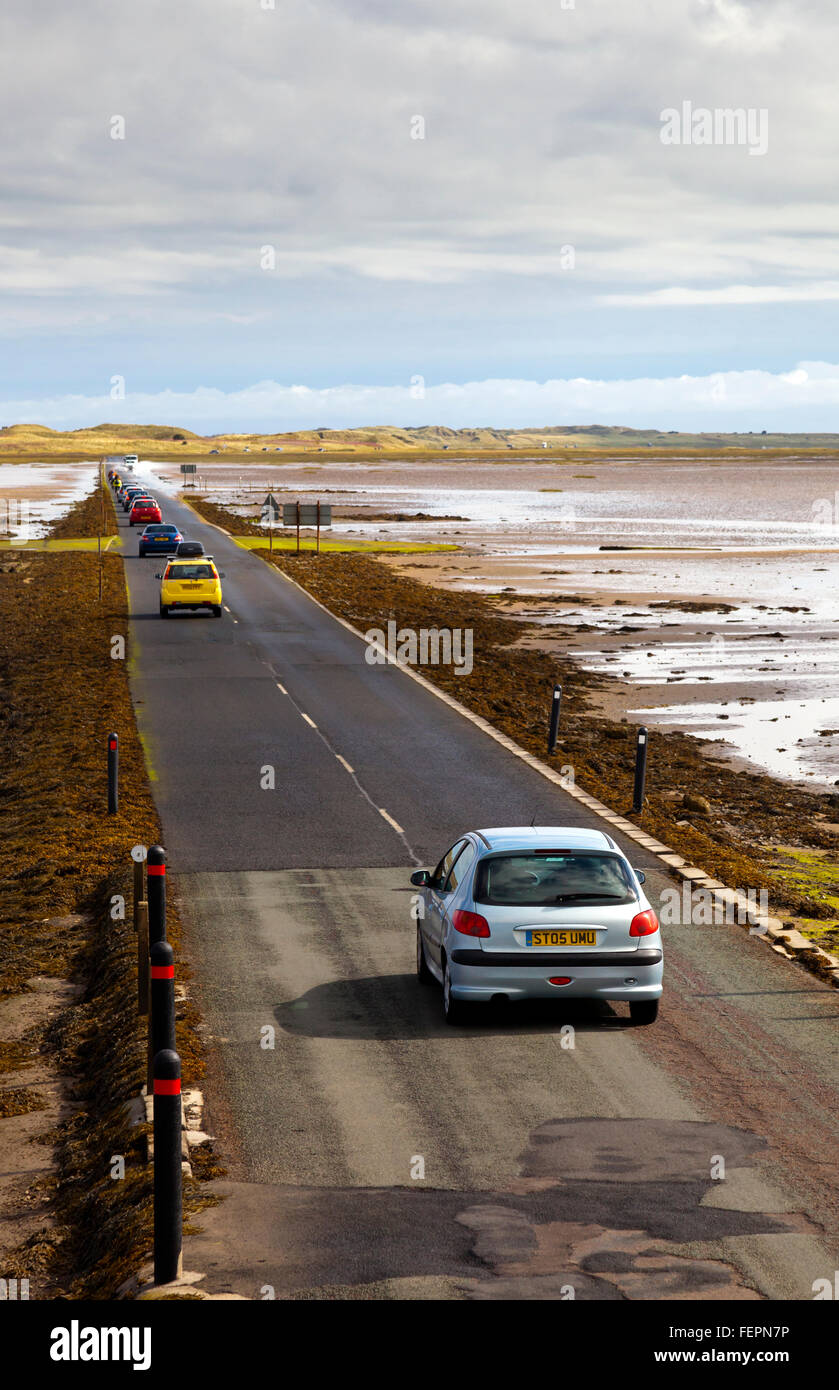 Cars on the causeway leading to Holy Island or Lindisfarne in Northumberland England UK which is cut off by the sea twice daily Stock Photo