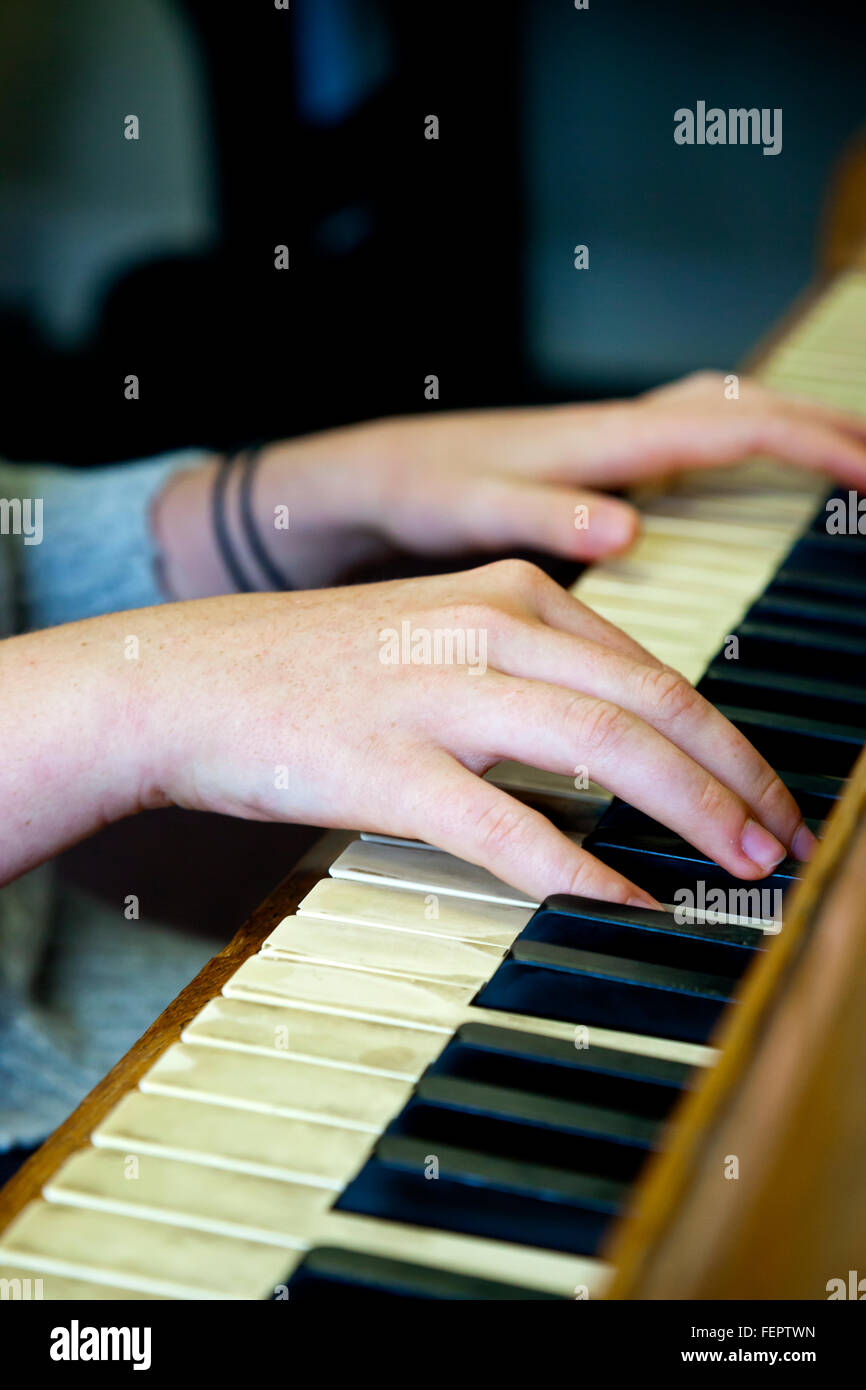 Close up view of the hands of a piano player with fingers on the keyboard Stock Photo