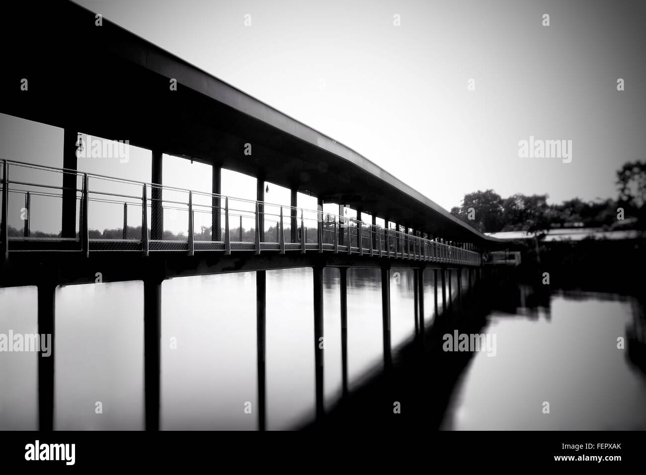 Reflection Of Bridge In Calm Sea Stock Photo