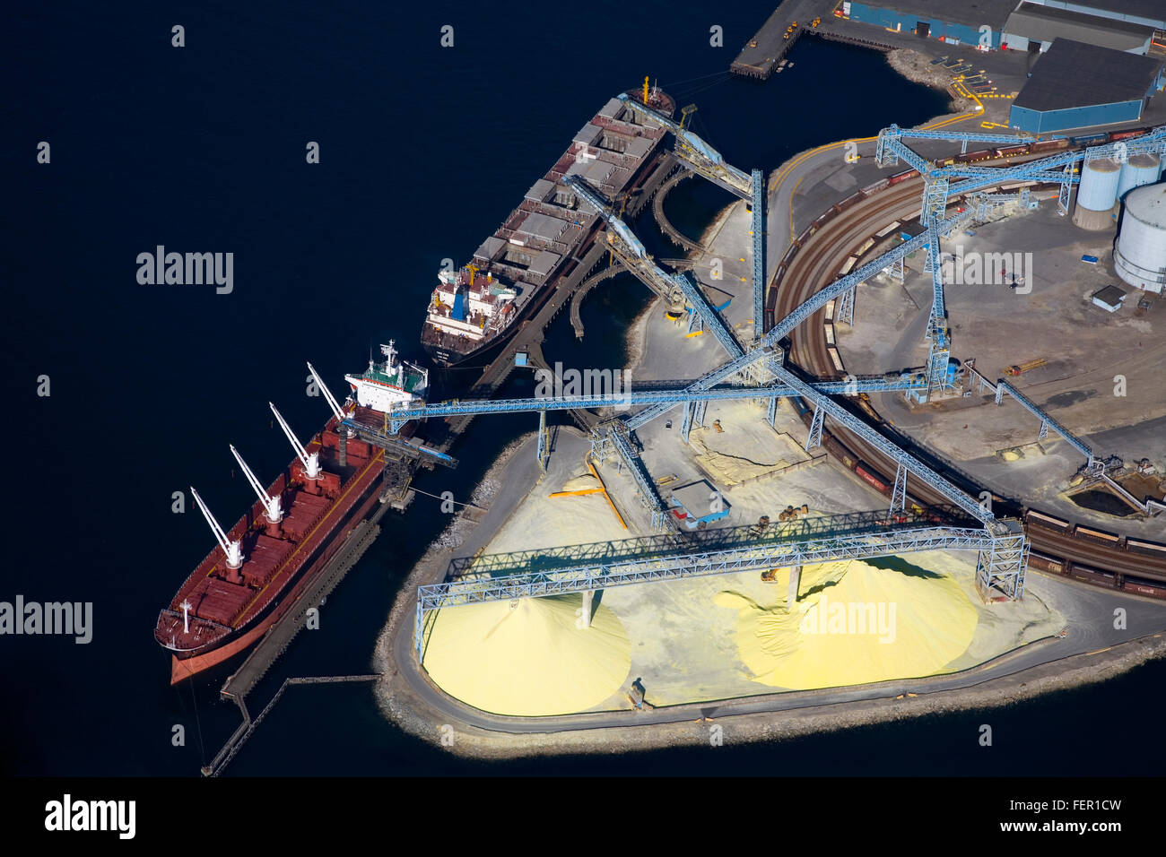 Ships loading sulfur at dock in North Vancouver, Canada, from the air. Stock Photo