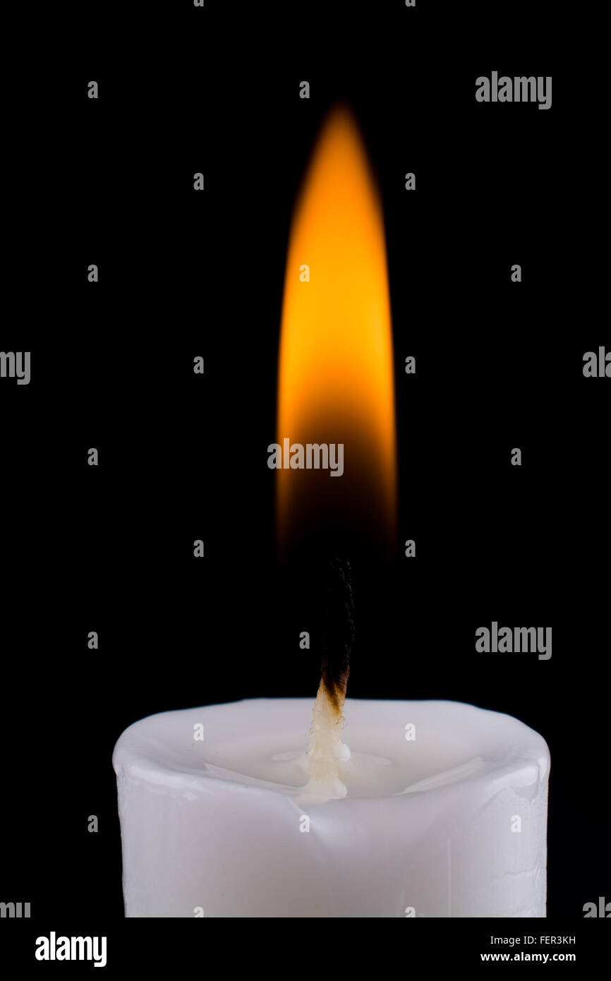 burning white candle on a black background Stock Photo - Alamy