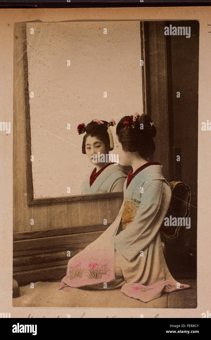 Traditional Geisha Mirror A traditional Japanese geisha is depicted by a mirror, reflecting the ...