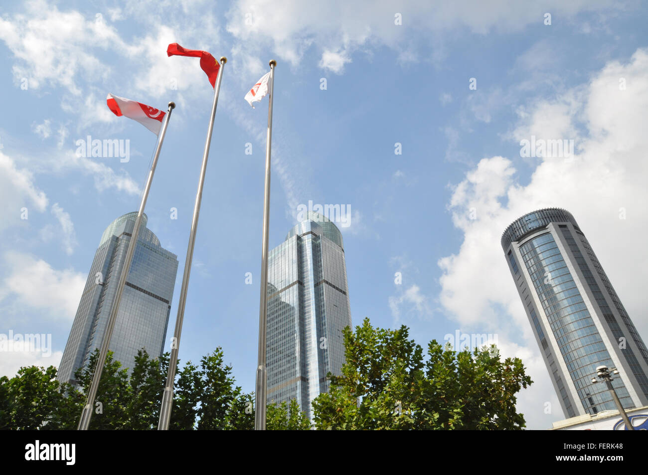 Low Angle View Of Singaporean Flags Against Modern Buildings In City Stock Photo