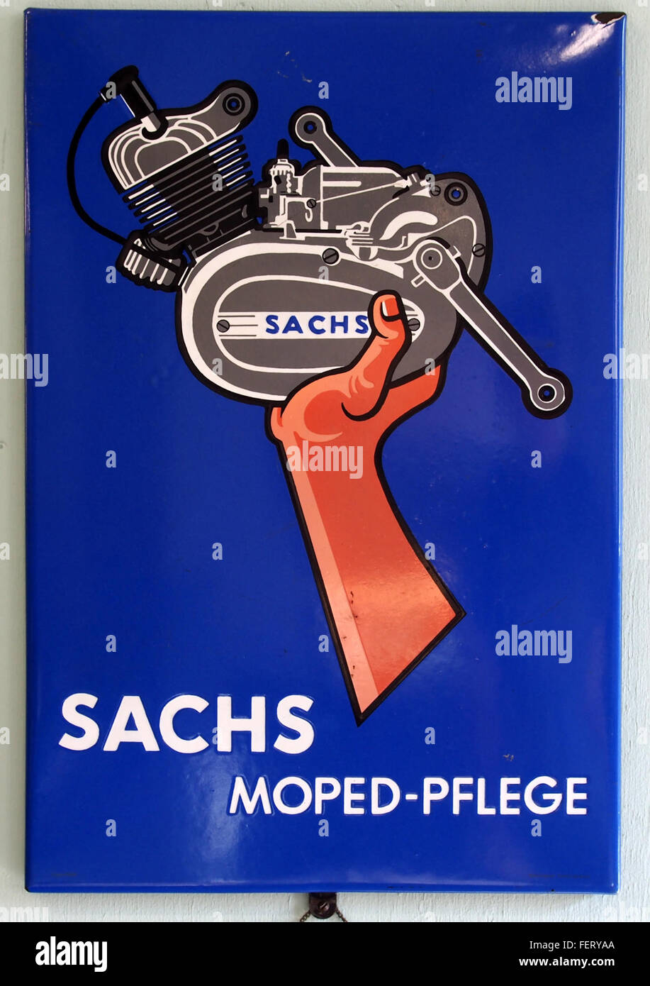 Sachs Moped-Pflege is an enamel advertising sign promoting Sachs moped maintenance products. The sign features vintage design elements and reflects the marketing style of moped care in earlier decades. Stock Photo