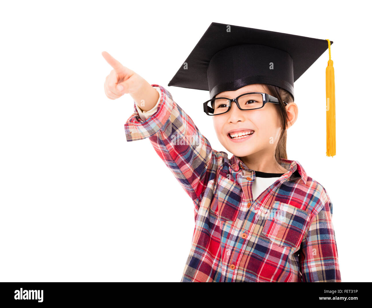 happy school kid in graduation cap with pointing gesture Stock Photo
