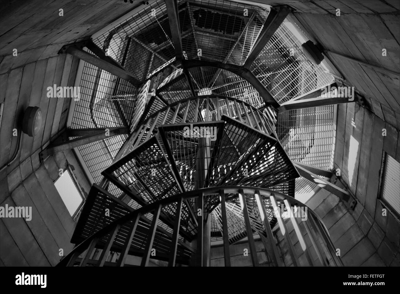 Vertical shot of a metal spiral staircase in a concrete observation tower. Stock Photo