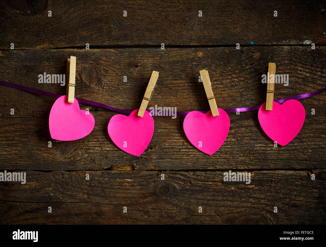 Pink heart paper cut out with clothes pins. Concept of Valentines day season Stock Photo