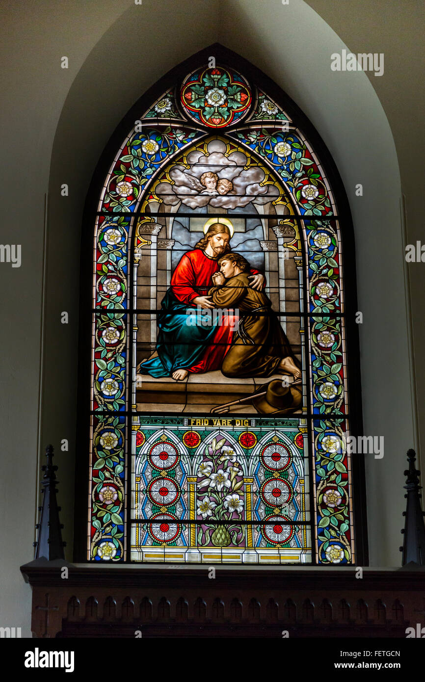 A stained glass window depicting Jesus Christ comforting a pilgrim inside The Church of St. Lawrence in Vantaa, Finland Stock Photo