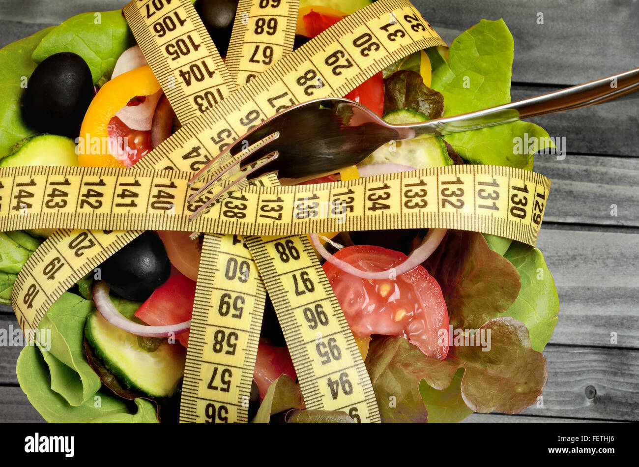 Vegetable salad with centimeter and fork on gray wooden table Stock Photo