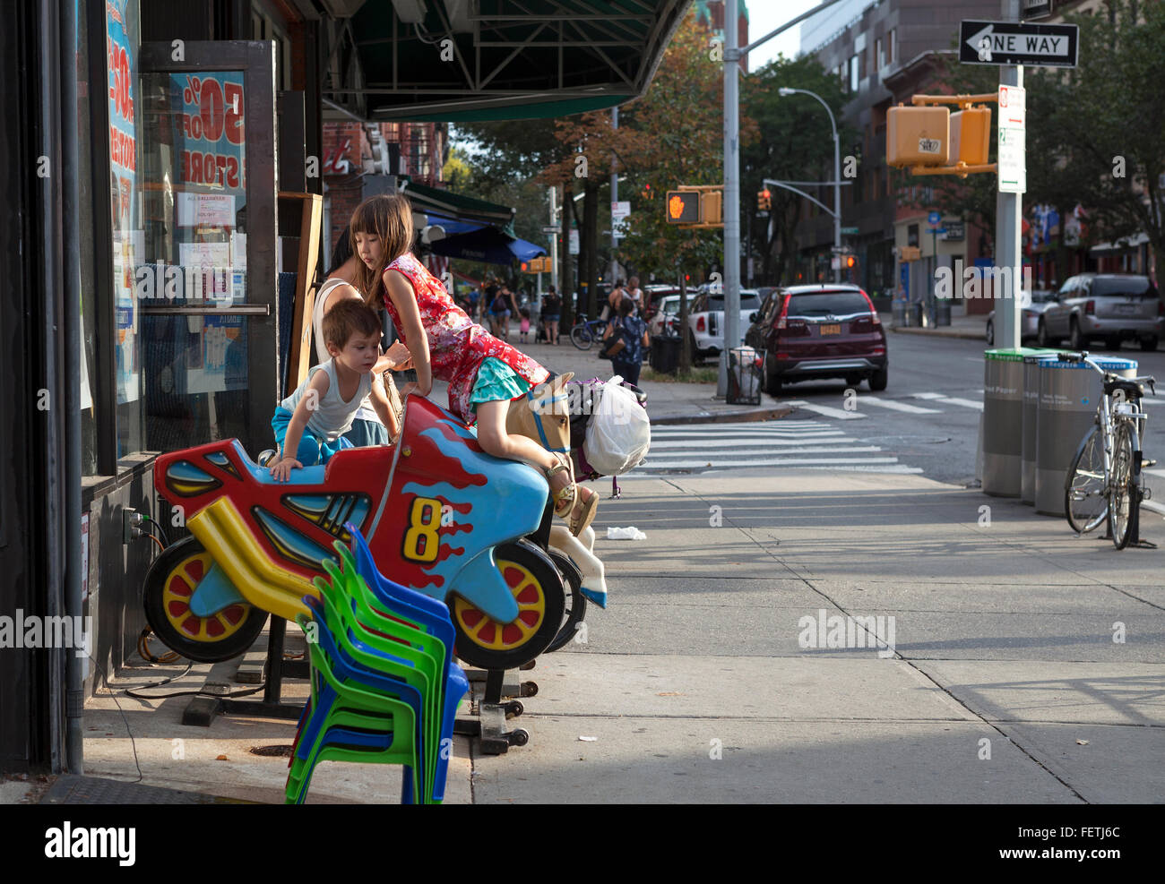 Children play on the rides outside a store in Brooklyn, New York City