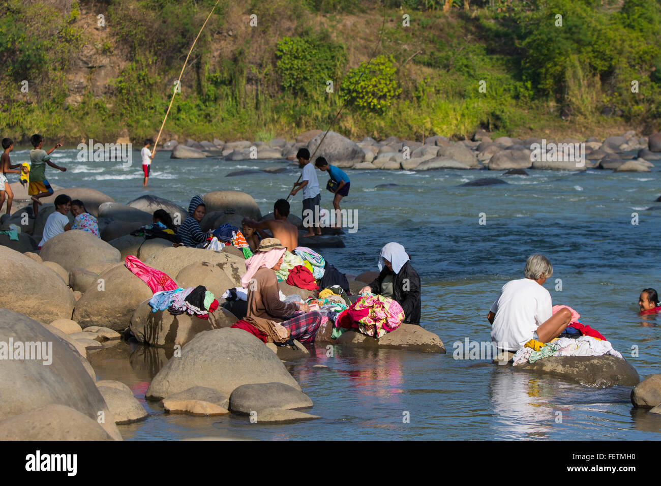 Filipino community washing clothes at side of a River Bank,Negros
