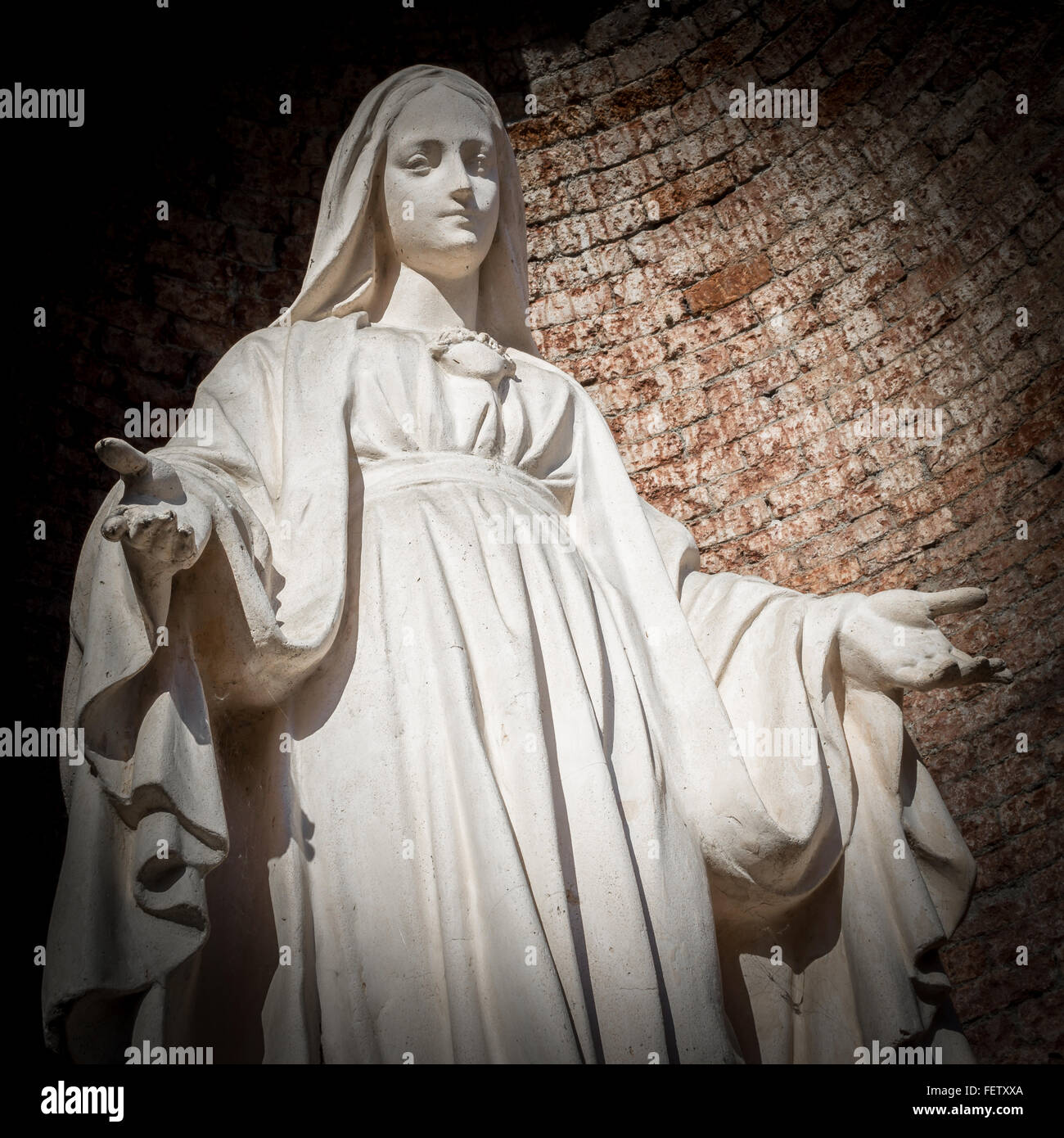 Statue of Virgin Mary in Roman Catholic Church on wall background. Stock Photo