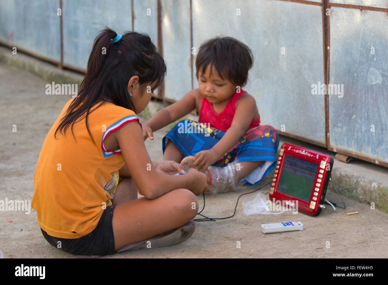 Young Filipino child playing a game on basic tablet. Stock Photo
