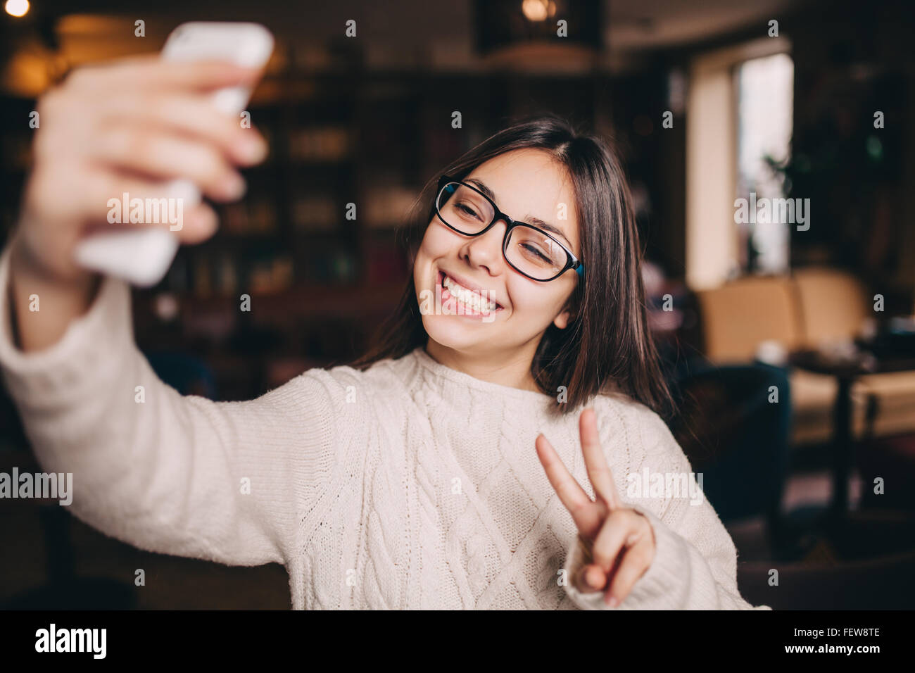 young smiling brunette woman making a selfie in a cafe Stock Photo