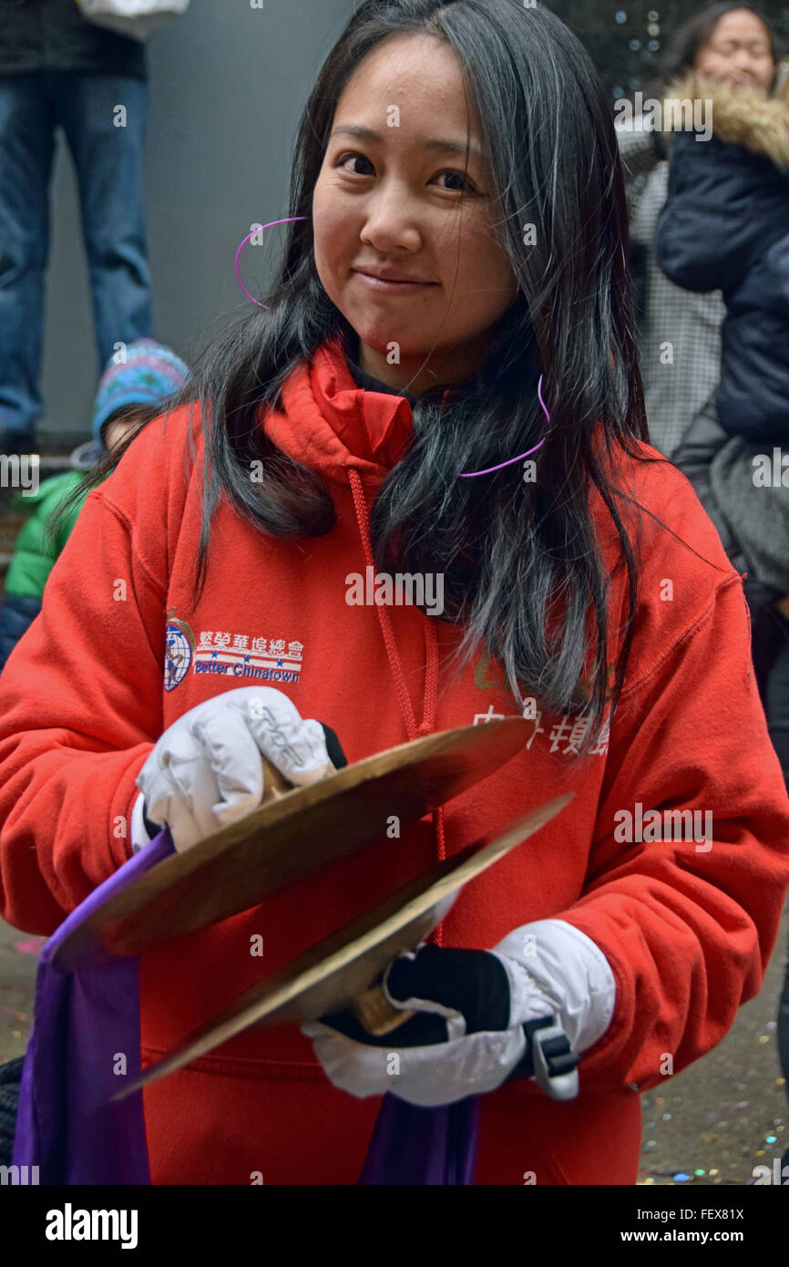 A pretty Chinese woman playing the cymbals in Chinatown New York on Lunar New Year's day, 2016 Stock Photo