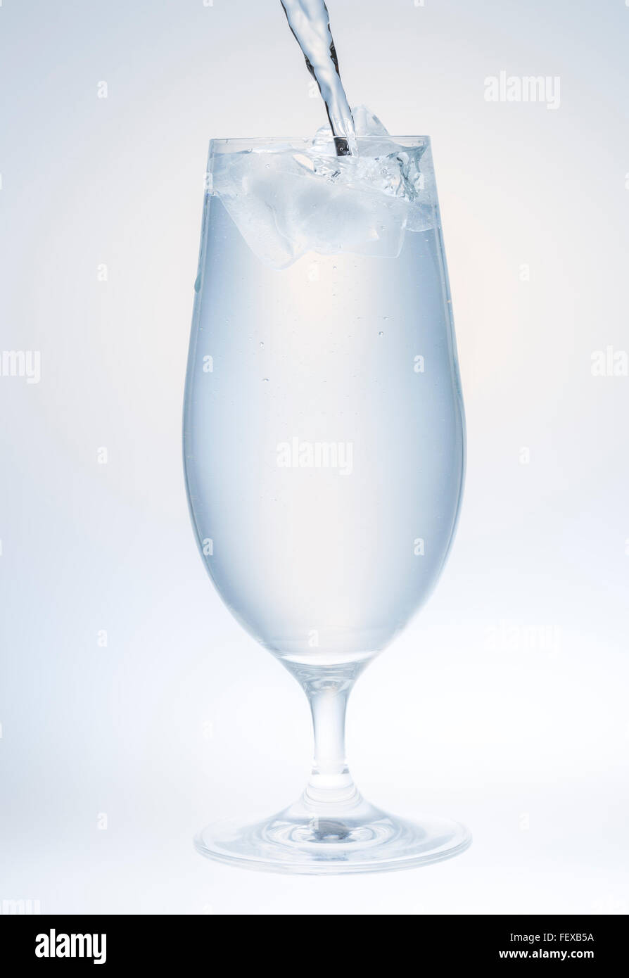 Water Pouring into Glass with Ice Stock Photo