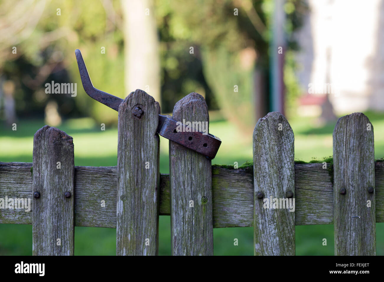 Old wooden fence door with metal latch leading to an English village church Stock Photo