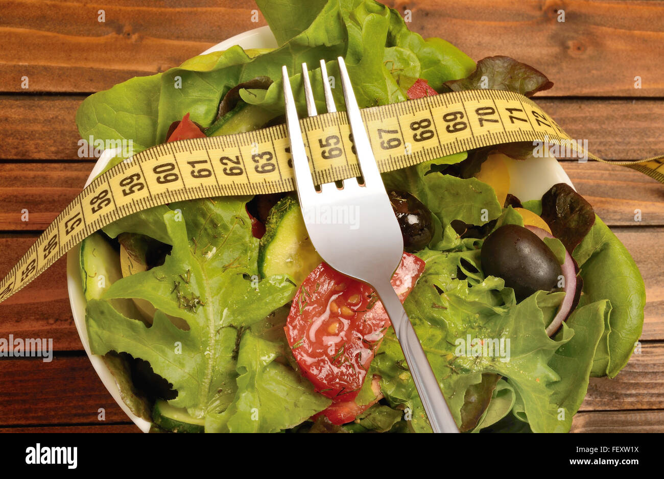 Vegetable salad with fork and centimeter on table Stock Photo