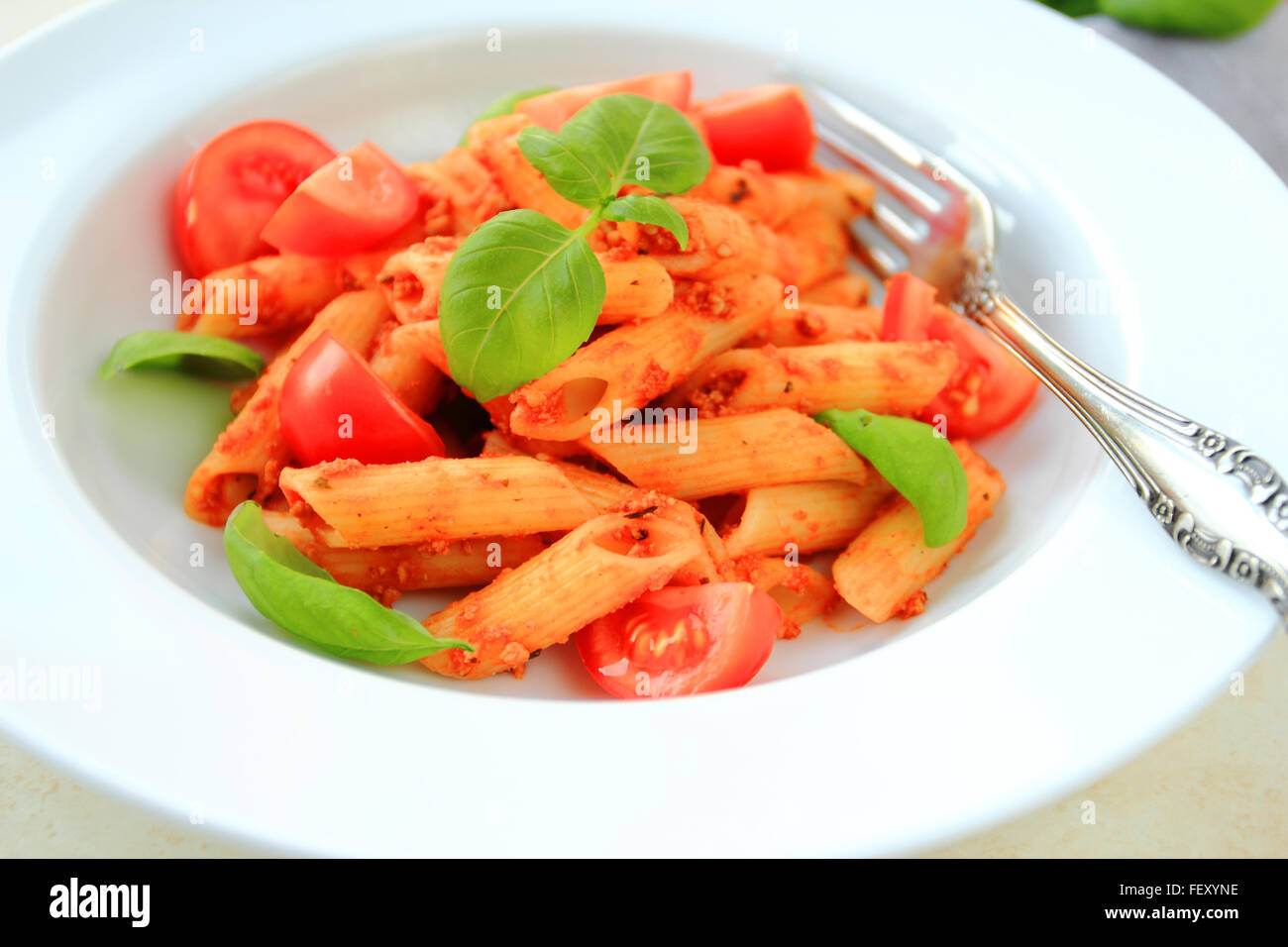 Penne pasta in tomato sauce on white plate Stock Photo