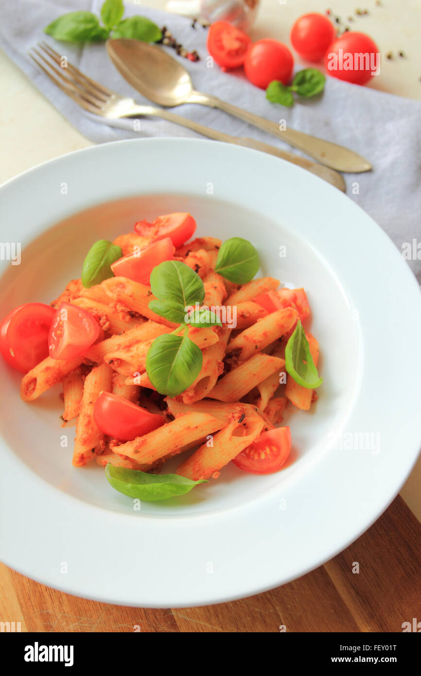 Penne pasta with bolognese sauce with fresh basil on white plate Stock Photo