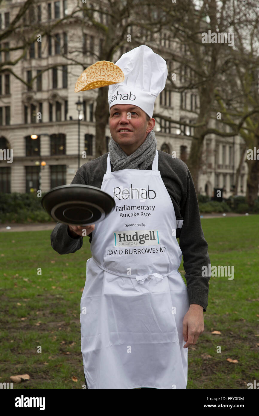 Westminster, London, UK. 9th February 2016. David Burrowes MP toses a pancake at the Rehab Parliamentary Pancake Race 2016 Credit:  Keith Larby/Alamy Live News Stock Photo