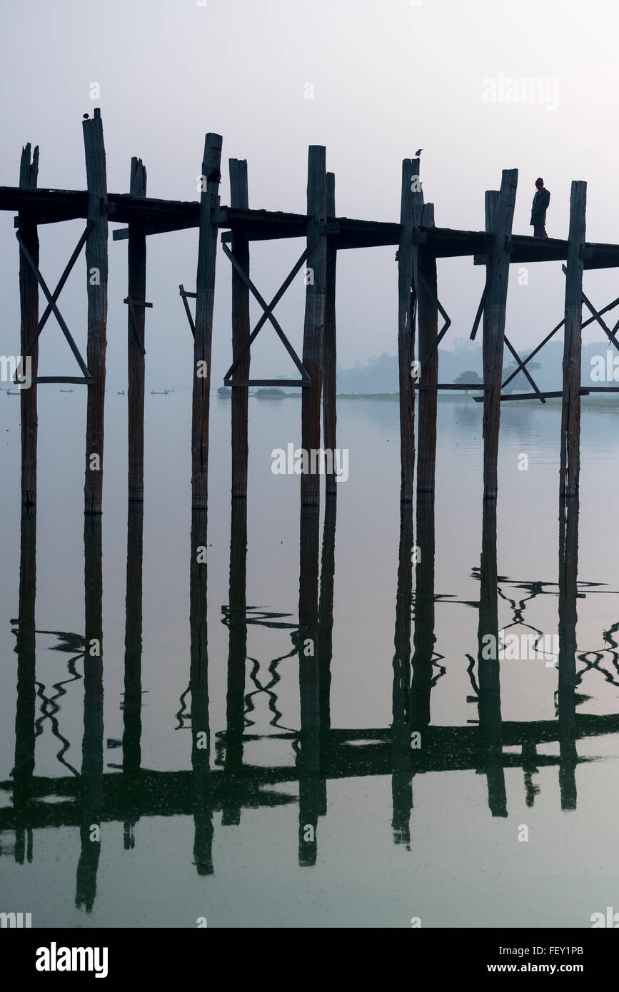 Man walks the U Bein Bridge across the Taungthaman Lake in Amarapura ...
