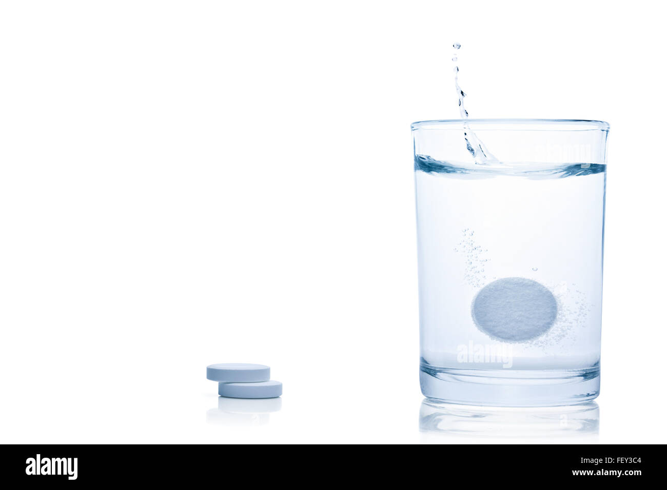 Fizzy pill splash in a glass of water, isolated on the white background, clipping path included. Stock Photo