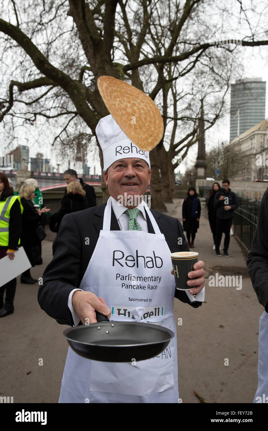 Westminster, London, UK. 9th February 2016. Alen Duncan multitasks by tossing a pancake in one hand and a cup of coffee in the other at the Rehab Parliamentary Pancake Race 2016 Credit:  Keith Larby/Alamy Live News Stock Photo