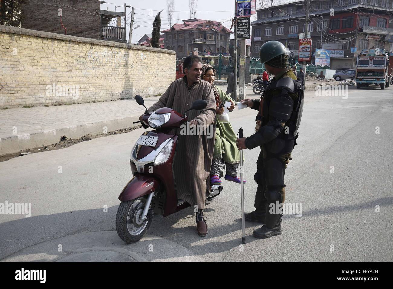 Srinagar, Indian-controlled Kashmir. 9th Feb, 2016. An Indian paramilitary trooper stops a couple on the scooter in Srinagar, summer capital of Indian-controlled Kashmir, Feb. 9, 2016. Curfew-like restrictions have been imposed in several areas of Srinagar city to prevent protests and clashes on the third death anniversary of Indian parliament-attack convict Mohammed Afzal Guru, officials said Tuesday. © Stringer/Xinhua/Alamy Live News Stock Photo