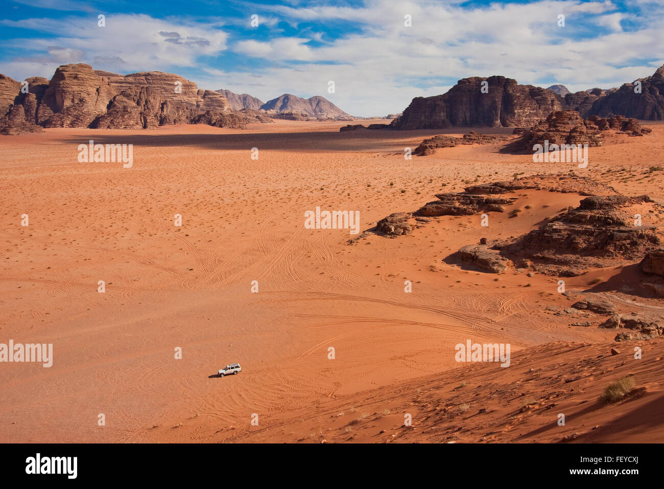 Small car in a huge desert of Wadi Rum. Shot from the only massive sand dune. Stock Photo