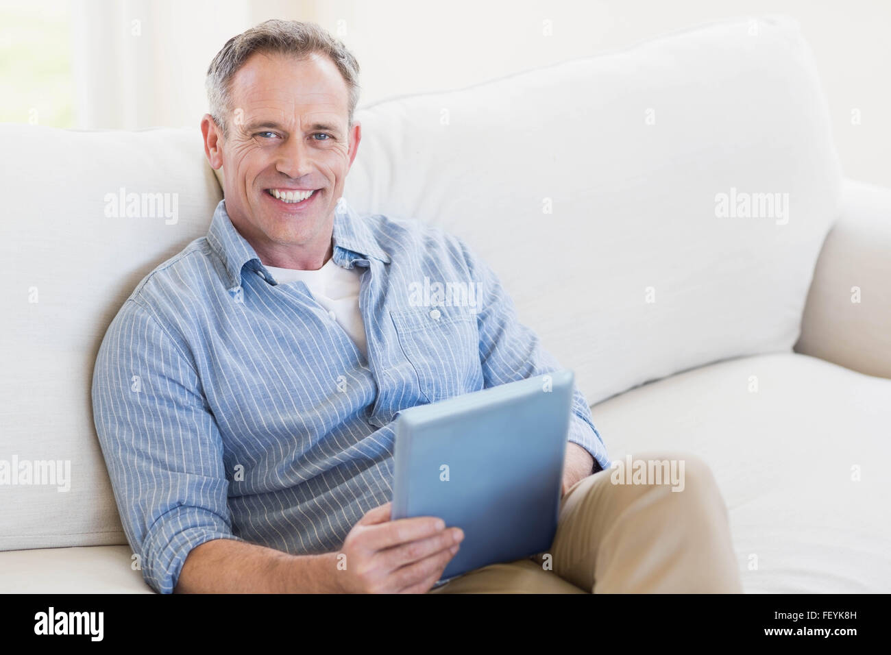 Happy man using tablet computer Stock Photo