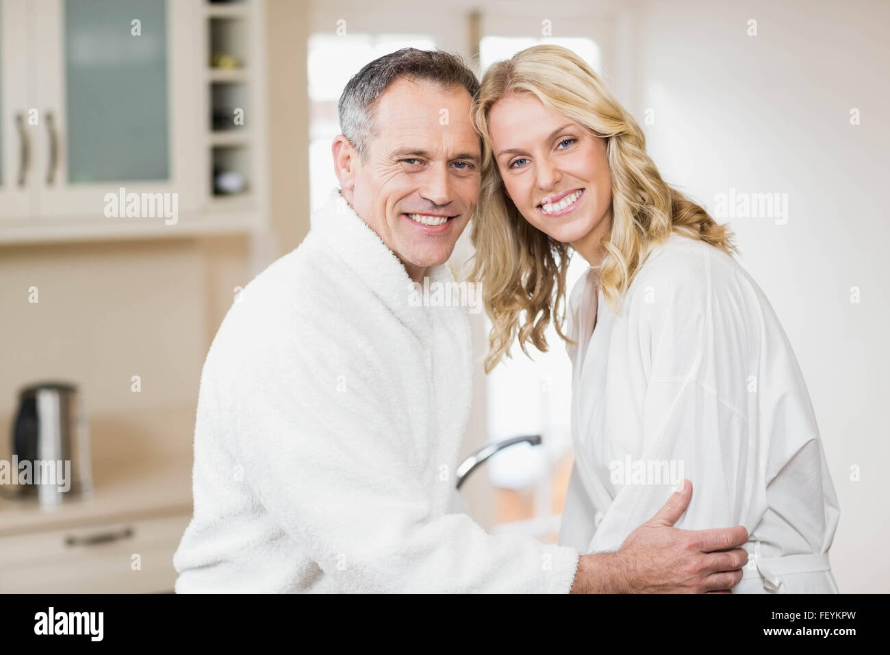Cute couple cuddling in bathrobes Stock Photo