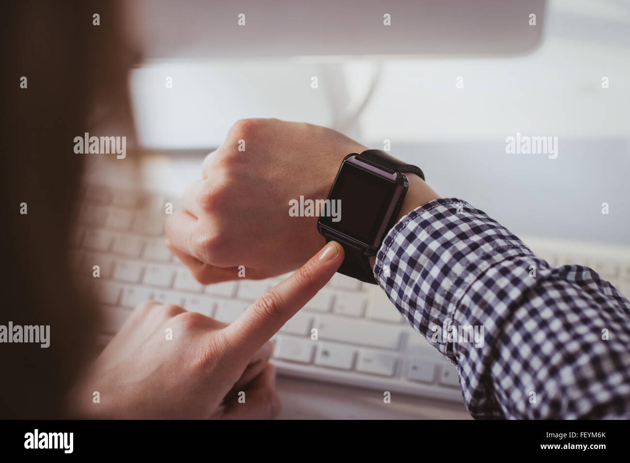 Over the shoulder view of businesswoman using her smart watch Stock Photo
