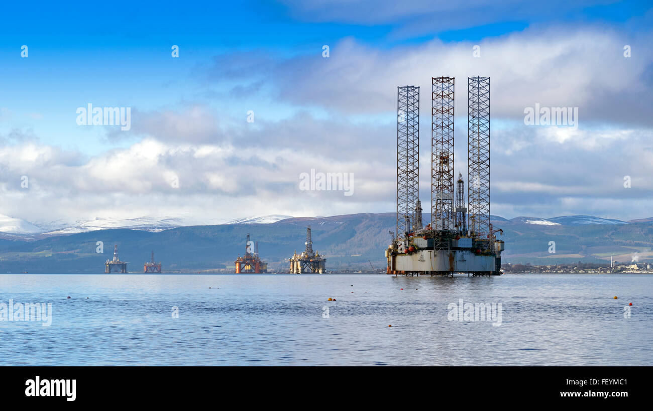 NORTH SEA OIL RIGS IN THE CROMARTY FIRTH WITH SNOW CAPPED HILLS AND INVERGORDON IN THE DISTANCE Stock Photo
