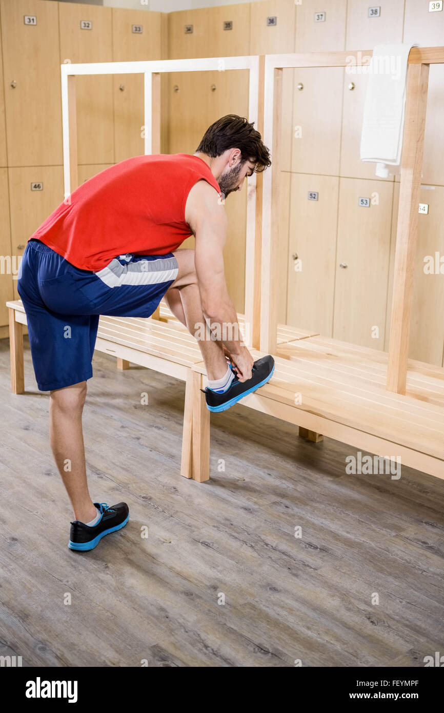 Man tying shoelace in locker room Stock Photo