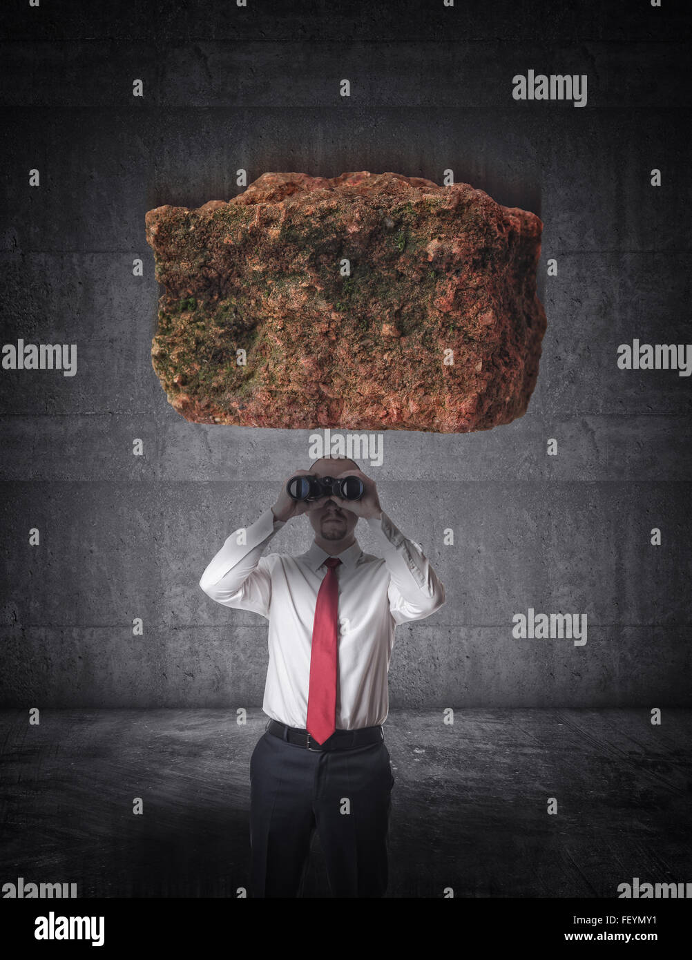 falling stone and businessman with binoculars Stock Photo